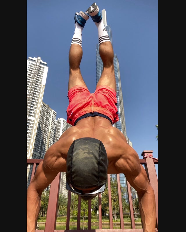 An inverted outdoor training movement photographed from a close, low angle.